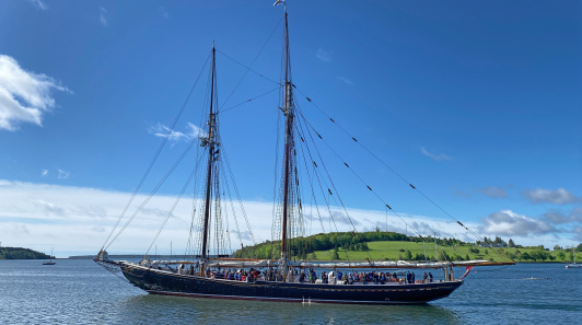 A traditional sailing ship sails on calm waters