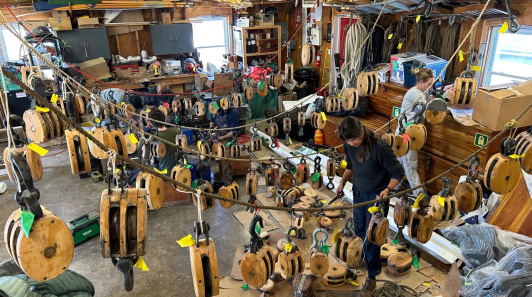 Workshop filled with wooden sailing blocks, ropes, and tools