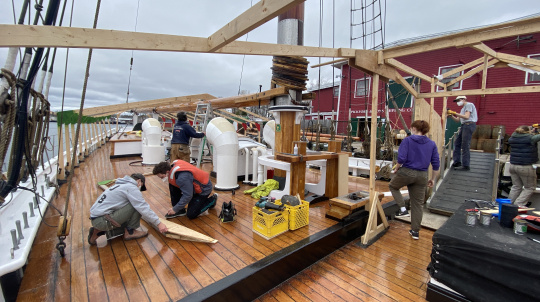 People working on the wooden deck of a ship.